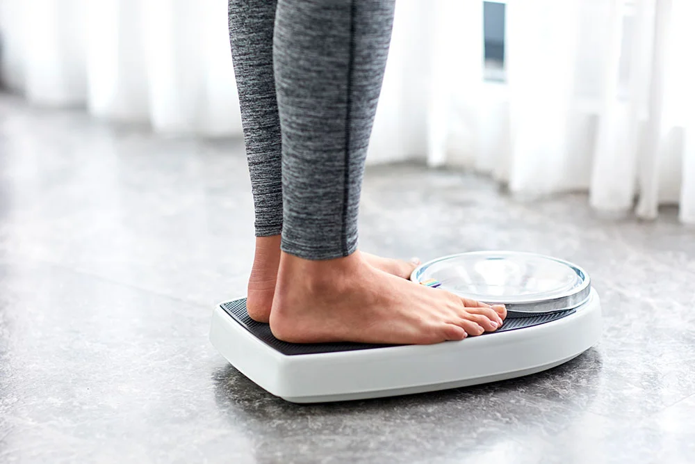 Woman standing on a bathroom scale